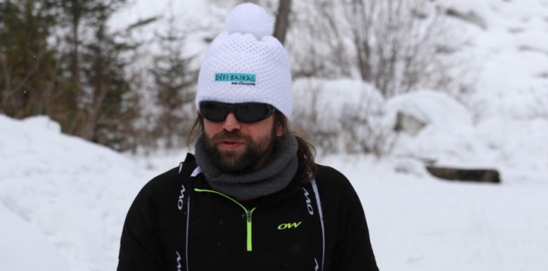 Photo de Nico en tenue noire sur la neige blanche avec le bonnet défi Baikal